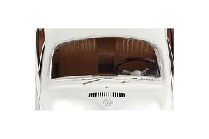 Close-up of the windshield and hood area of a white VW Beetle model car, showing the steering wheel, dashboard, and Volkswagen logo.
