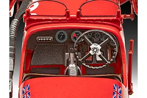Close-up of the detailed interior cockpit of a red Revell 1/32 scale Aston Martin Ulster model car, featuring a steering wheel, dashboard gauges, and Union Jack decals.