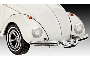Close-up of the front end of a white Revell 1/32 scale VW Beetle model car, showing the bumper, headlight, and license plate.