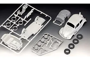 Unassembled plastic model kit parts for a 1/32 scale VW Beetle, including a car body, chassis sprue, wheel sprue, and four rubber tires.