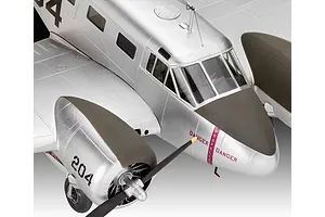 Close-up of a 1/48 scale Beechcraft Model 18 plastic model aircraft, showing the silver fuselage, cockpit windows, and engine cowling with propeller.