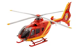 A completed 1/72 scale plastic model of an Airbus EC135 helicopter in Air-Glaciers livery, featuring red and yellow paint with medical markings.