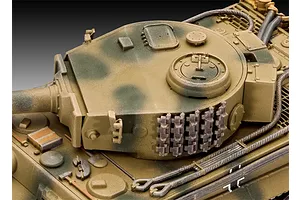 Close-up of a 1/72 scale plastic model Tiger tank turret with camouflage paint and spare track links mounted on the side.