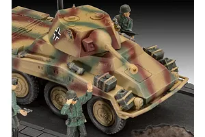 A 1/76 scale plastic model of a German Sd.Kfz. 234-2 Puma armored car with camouflage paint, featuring two painted soldier figures on a display base.