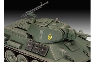 Close-up of a 1/76 scale plastic model T-34-76 tank, showing the turret, machine gun, and green camouflage paint.