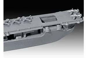 Close-up of a grey plastic model aircraft carrier deck showing molded aircraft and structural details.
