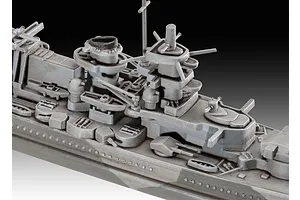 Close-up of the superstructure and deck of a grey plastic model battleship, showing detailed gun turrets, funnels, and masts.