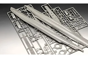 Grey plastic model kit sprues for a 1/144 scale U-boat submarine, showing hull halves and various small detailed parts on frames.