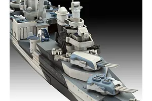 Close-up of a painted 1/700 scale plastic model warship showing the forward deck, gun turrets, and bridge structure with a blue and white camouflage pattern.