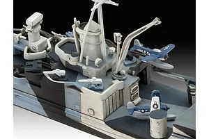 Close-up of a 1/700 scale model ship deck featuring a crane, radar mast, and two small floatplanes with US Navy markings.