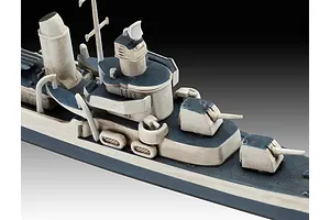 A close-up view of a painted plastic model warship, showing the deck, gun turrets, and superstructure in grey and off-white.