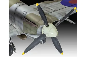 Close-up of a 1/32 scale Supermarine Spitfire model aircraft showing the nose, propeller, and wing detail with weathered camouflage paint.