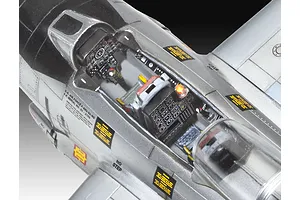 Close-up of a detailed plastic model aircraft cockpit showing instrument panels, seat, and decals on a silver fuselage.