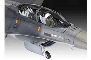 Close-up of the cockpit and nose section of a 1/72 scale plastic model F-16 fighter jet, showing the pilot figure and detailed decals.