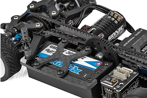 Close-up of the chassis of a Team Associated TC28 RC car showing the battery, motor, and internal components.