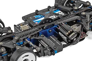 Close-up of the internal chassis components of a Team Associated RC car, showing the motor, servo, and battery placement.