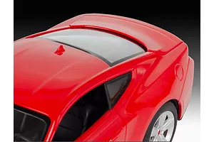 High angle close-up of a red 1/25 scale Ford Mustang GT model car showing the roof, rear window, and side panel.