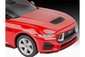 A close-up view of the front end of a red Revell 1/25 scale 2024 Ford Mustang GT model car, showing the hood, headlight, and wheel.