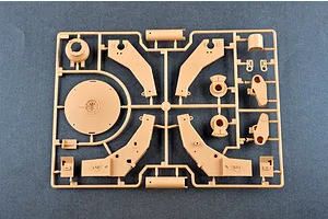 A tan plastic model kit sprue containing various parts for an M198 155mm towed howitzer, set against a dark grey background.