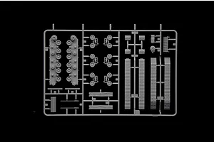 A grey plastic sprue containing various tank model parts including road wheels, track sections, and suspension components.