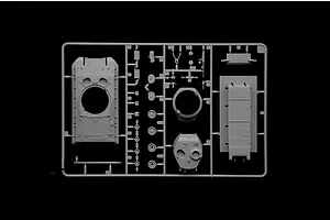 A grey plastic sprue containing various unpainted model tank parts, including the hull, turret, and small components, against a black background.