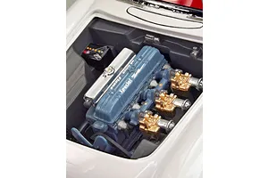 A close-up view of the detailed engine bay of a 1/24 scale 1953 Chevrolet Corvette model kit, featuring a blue Blue Flame engine block.