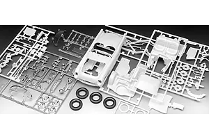 A collection of unpainted white plastic model car parts on sprues, including a car body, interior, and chrome-plated parts, with three black rubber tires.