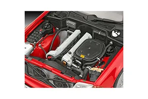 Close-up of the detailed engine bay of a 1/24 scale Revell Mercedes-Benz 300 SL-24 model car, showing the engine block, radiator, and red bodywork.