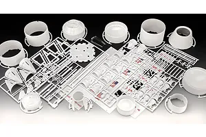 Unassembled plastic model kit parts for a Revell Saturn V rocket, including white cylindrical sections, engine nozzles, and decal sheets.