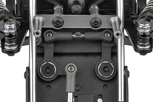 Close-up view of the front suspension and steering assembly of a Team Associated RC10 Sprint RC car kit, showing metal rods, plastic parts, and screws.
