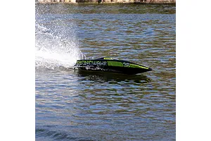 A black Pro Boat Sonicwake V3 RC speed boat racing across the water, creating a large splash behind it.