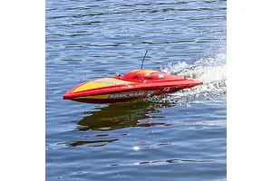 A red and yellow Pro Boat Sonicwake 36 RC speed boat racing across blue water, creating a wake behind it.