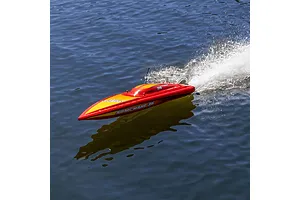 A red and yellow Pro Boat Sonicwake 36 RC speed boat racing across blue water, creating a white wake behind it.