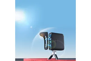 SkyRC LapWiz smart lap timing system mounted on a small tripod against a bright blue sky background.