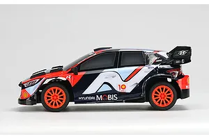 Side view of a Carisma 1/24 scale Hyundai i20N Rally1 RC car featuring a blue, red, and white livery with Hyundai Mobis branding on a white background.