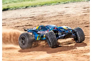 A Traxxas Rustler VXL RC stadium truck driving fast on a dirt track, kicking up dust behind its rear wheels.