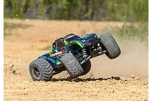 Traxxas Stampede 4X4 VXL RC monster truck performing a wheelie on a dirt track with dust kicking up.