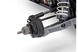 Close-up of the front suspension assembly of a Traxxas RC vehicle, showing the steering block, wheel hex, and shock absorber.