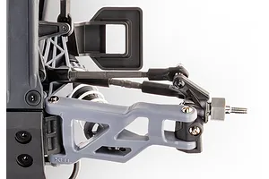 Close-up of the front suspension assembly on a Traxxas RC vehicle, showing the grey control arm, steering links, and wheel hex hub.