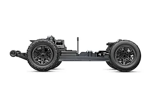 Side view of a Traxxas RC stadium truck chassis without the body shell, showing the wheels, suspension, and drivetrain components.