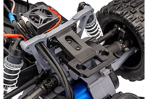 Close-up of the rear suspension and chassis components of a Traxxas RC stadium truck, showing the shock tower, motor, and transmission housing.