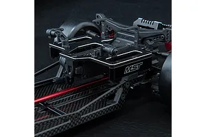 Close-up of an MST aluminium rear battery mount installed on a carbon fibre RC chassis, featuring a black finish with the MST logo.