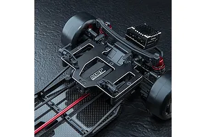 A black MST aluminium battery and servo mounting plate installed on an RC drift car chassis.