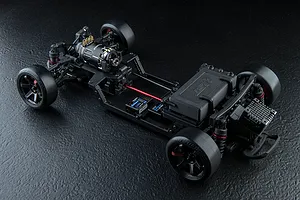 High-angle studio shot of an MST FRX S 1/10 scale RC drift car chassis, showing the motor, electronics, and drivetrain on a black textured surface.