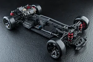 High-angle studio shot of an MST RMX 4 S Pro RC drift car chassis, showing the rear-mounted motor, suspension, and drift tires on a textured black surface.