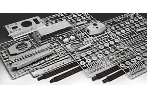 Grey plastic model kit sprues for a Tiger II tank, including hull, turret, and track parts on a white background.