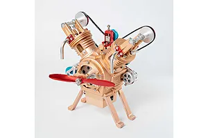 A gold-coloured Teching M114 V2 engine model kit with a red propeller, standing on a white background.