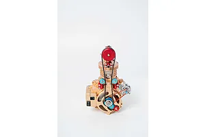 A front view of the Teching DM117 single cylinder engine metal model kit featuring gold, red, and blue components on a white background.