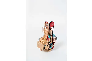 A gold-coloured Teching DM117 single cylinder engine model kit featuring red and blue accents, belts, and gears against a plain white background.