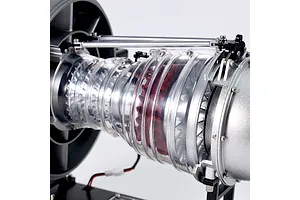 Close-up of the Teching DM121 civil turbofan engine model kit showing internal red turbine blades and clear plastic casing.